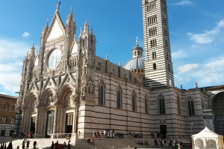Gothic-style cathedral with ornate facade and tall bell tower against a blue sky.