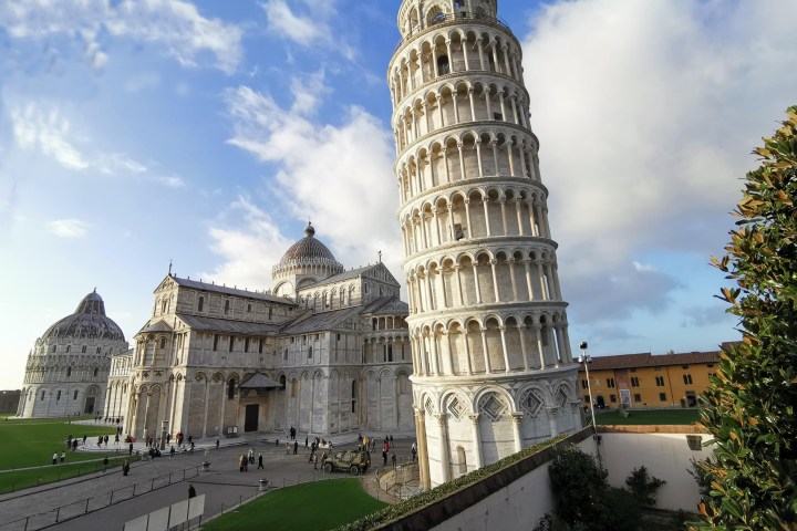 Leaning Tower of Pisa with surrounding cathedral and blue sky.
